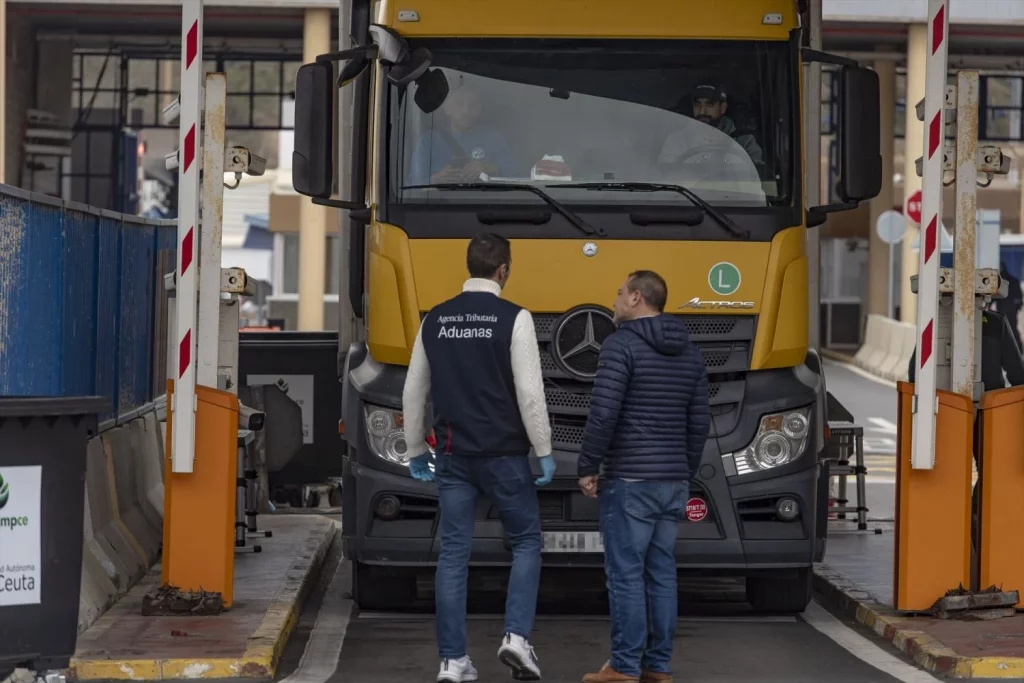 Dos personas delante del primer camión que ha pasado por la aduana comercial de Ceuta, a 21 de febrero de 2025, en Ceuta (Fuentes: Agencias)