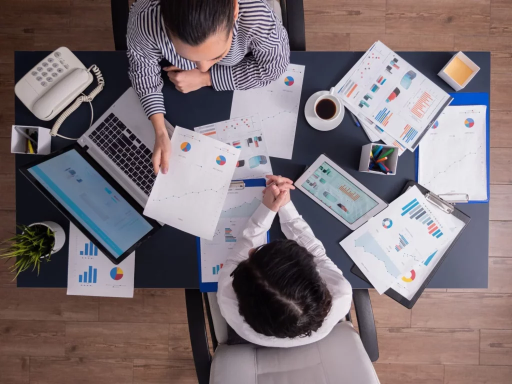 Harvard enumera las carreras donde menos sudas y más avanzas 14 Moncloa top view office workers meeting analyzing financial charts holding clipboard Moncloa