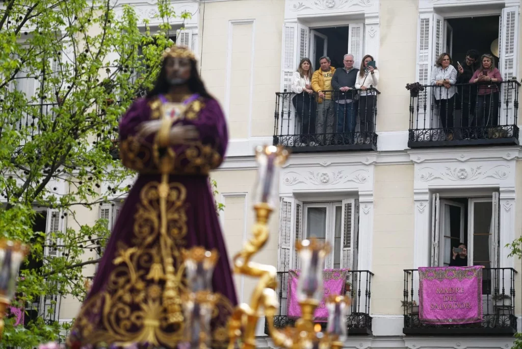 Varias personas observan desde los balcones el paso de Nuestro Padre Jesús Nazareno el Pobre durante la procesión del Jueves Santo, a 17 de abril de 2025, en Madrid (Fuente: Agencias)