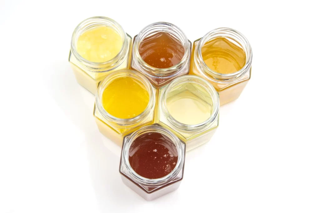jars with different types colors honey white background organic vitamin food Moncloa