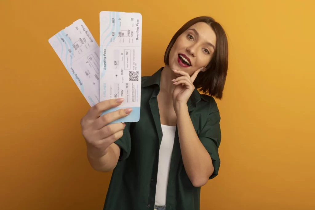 Este es el código oculto en tu billete de avión revela si eres un pasajero 'marcado' por la aerolínea 3 Moncloa joyful pretty caucasian woman puts hand face holds air tickets orange Moncloa