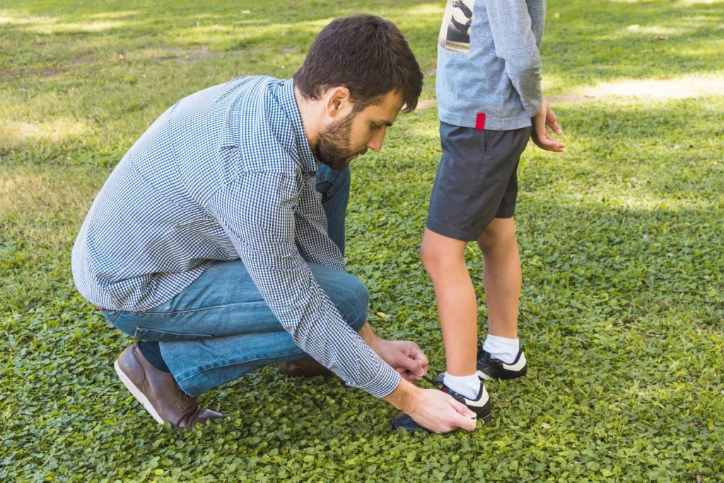 man tying shoelace his son park Moncloa