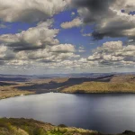 Un lago glaciar que parece Suiza y está a tres horas de Madrid: playas de piedra, barquitos y un pueblo mínimo a la orilla