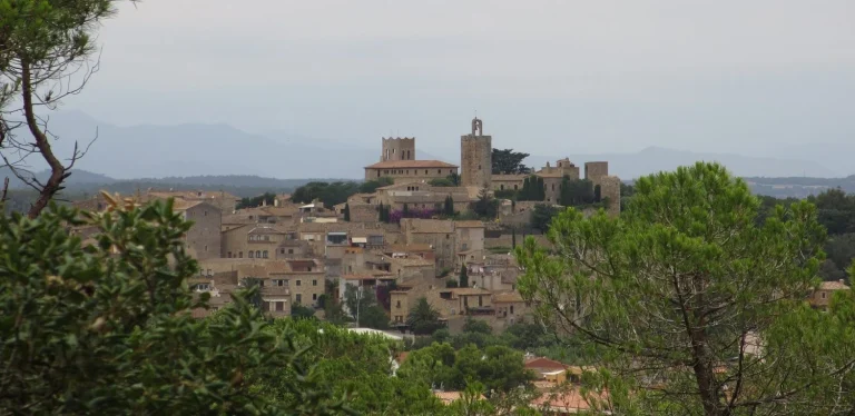 Este pueblo a 45 minutos de Barcelona rompe el algoritmo porque crece sin turismo masivo: castillo medieval funcional, mercado de pueblo todos los martes donde compra la gente de verdad, y arrozales donde nace la gastronomía local