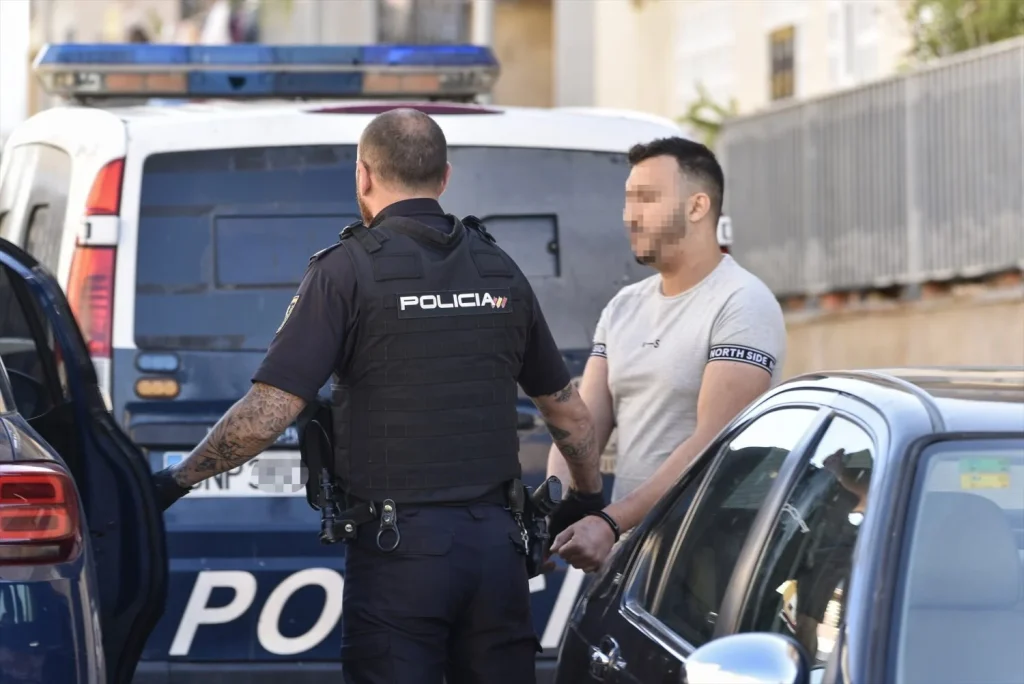 EuropaPress 4541732 agente policia nacional lleva detenido esposado dispositivo marco operativo Moncloa