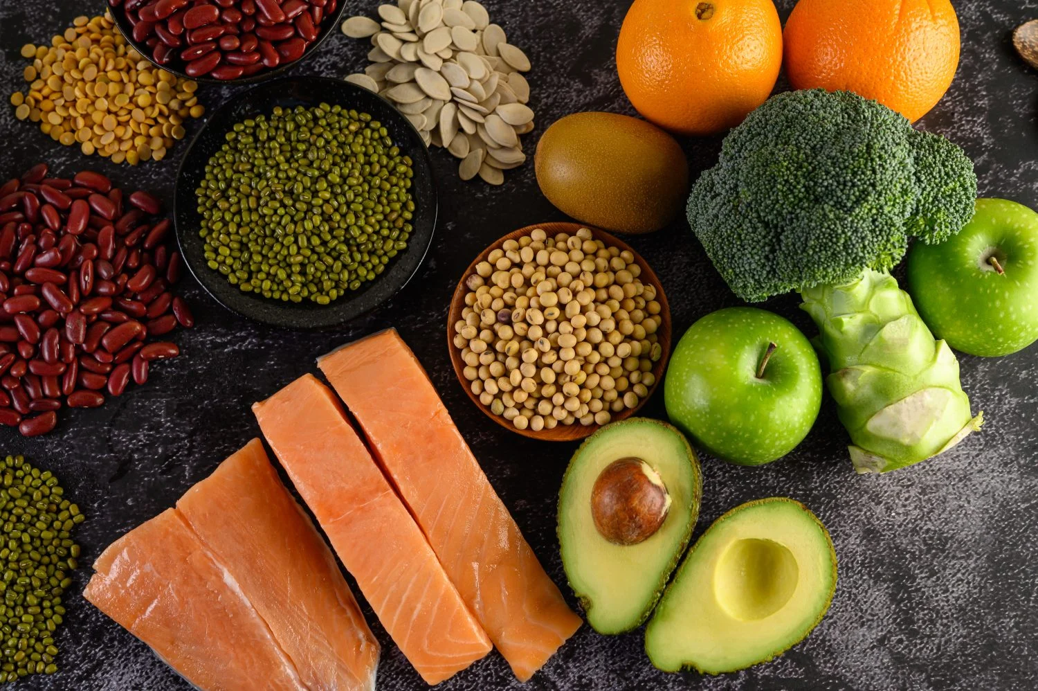 legumes-broccoli-fruit-salmon-placed-black-cement-floor