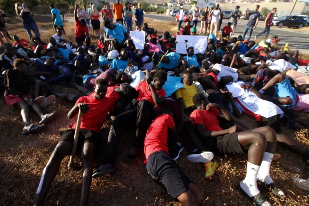 Varias personas migrantes tiradas en el suelo simulan las imágenes de los cuerpos tendidos en el salto a la valla de Melilla (Foto: Europa Press) Varias personas migrantes tiradas en el suelo simulan las imágenes de los cuerpos tendidos en el salto a la valla de Melilla (Foto: Europa Press)