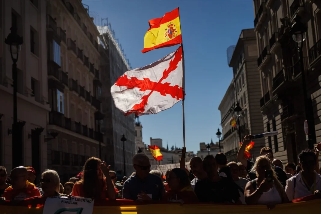 Varias personas portan una bandera de España y otra con la cruz de Borgoña durante una manifestación para protestar por la gestión del Ejecutivo central Varias personas portan una bandera de Espana y otra con la cruz de Borgona durante una manifestacion para protestar por la gestion del Ejecutivo central Moncloa