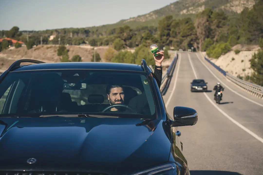 A car driving down a road next to a motorcycle