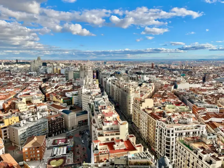 Impresionante vista aérea del horizonte de Madrid con un paisaje urbano vibrante bajo un cielo azul.